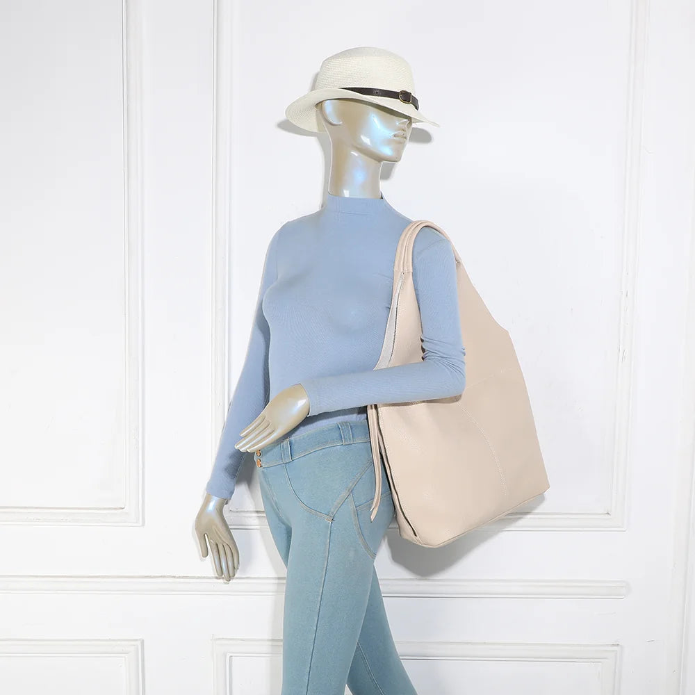 Sac Noxa beige porté à l’épaule par une femme, grâce à ses deux anses souples – réf. R-2051
