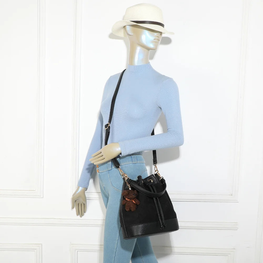 Sac seau Oria Suédine noir porté par une femme, en bandoulière réglable et amovible