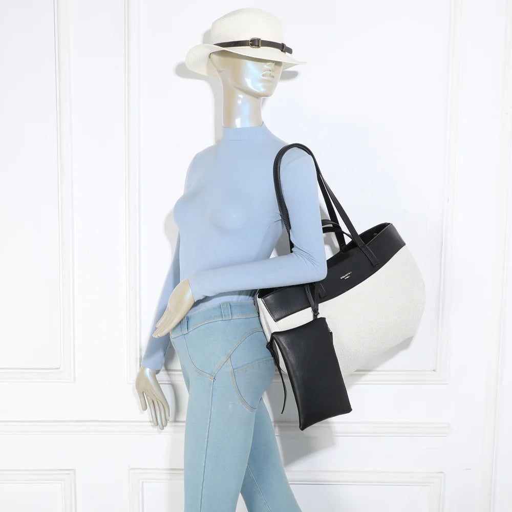 Cabas Palazzo beige/noir porté à l’épaule par une femme grâce à ses deux longues anses – réf. R-2044