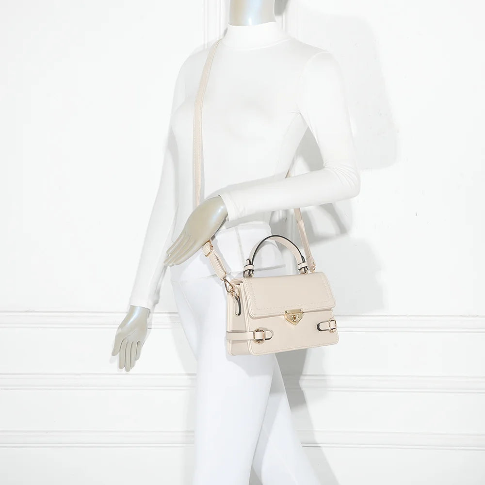 Petit Chic beige porté par une femme, un petit sac à main structuré avec ses boucles dorées – réf. C-0176-2