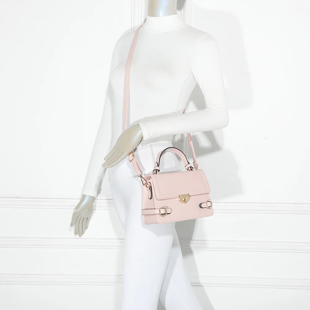 Petit Chic rose porté par une femme, un petit sac à main structuré avec ses boucles dorées – réf. C-0176-2