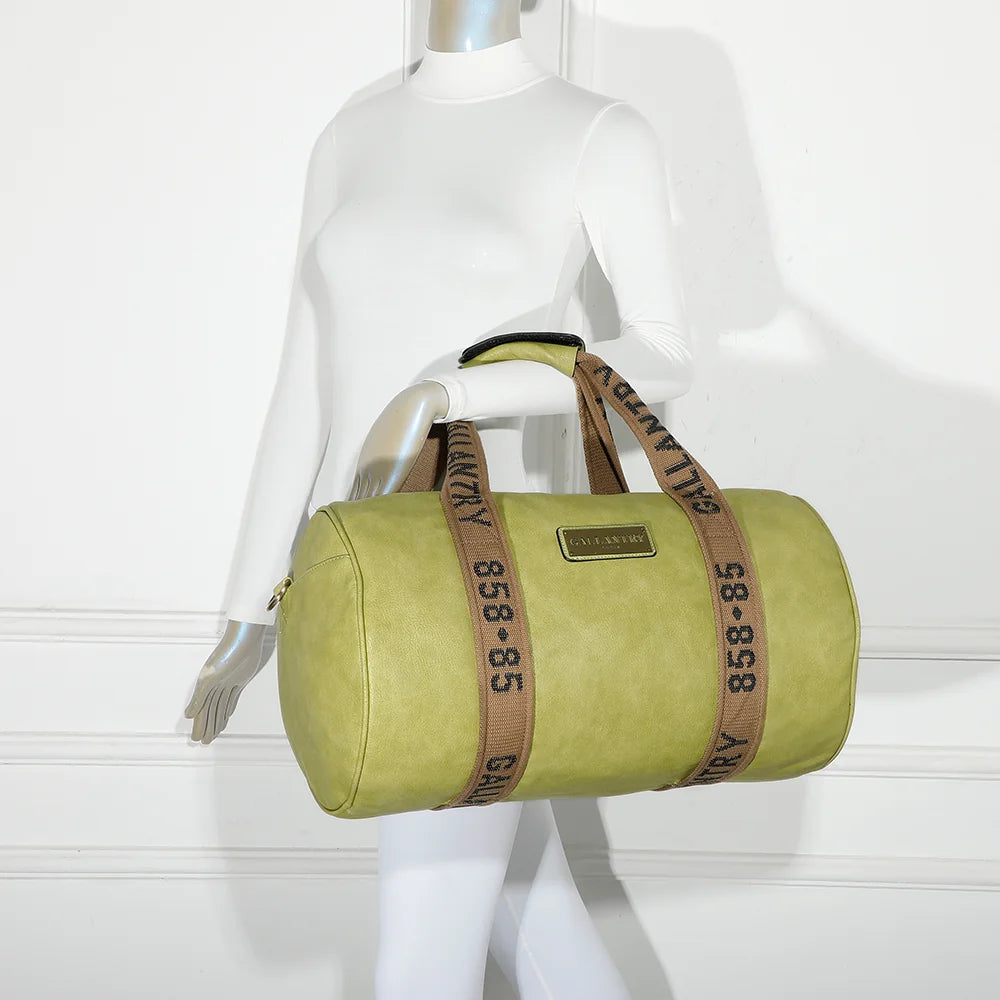 Sac de voyage Polochon vert pomme porté à l’épaule par une femme grâce à sa bandoulière amovible – réf. Z-83049