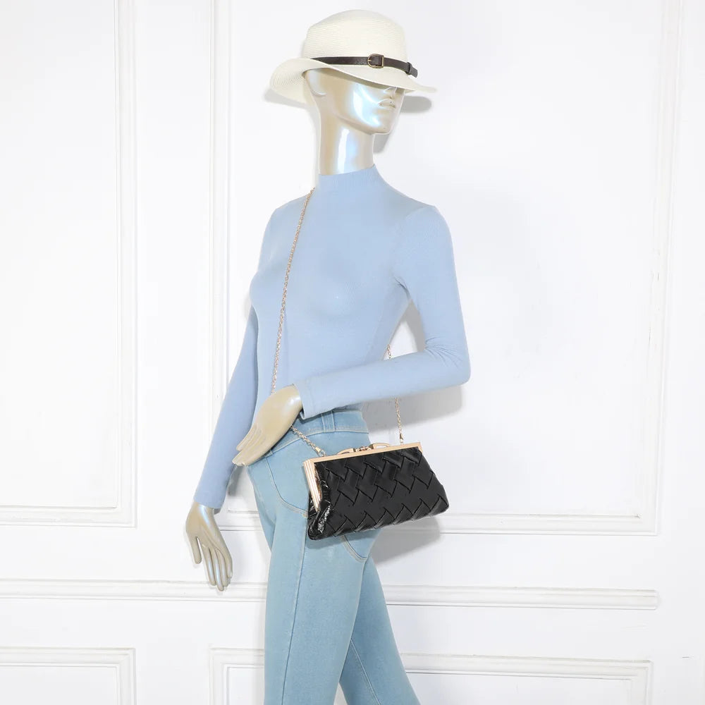 Pochette Shine noir portée par une femme, à l’épaule grâce à sa fine chaîne métallique amovible – réf. LH-71004