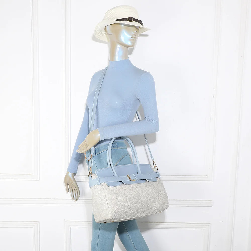 Sac Soft Belt bleu clair porté par une femme, à la main ou avec sa bandoulière amovible – réf. R-2037