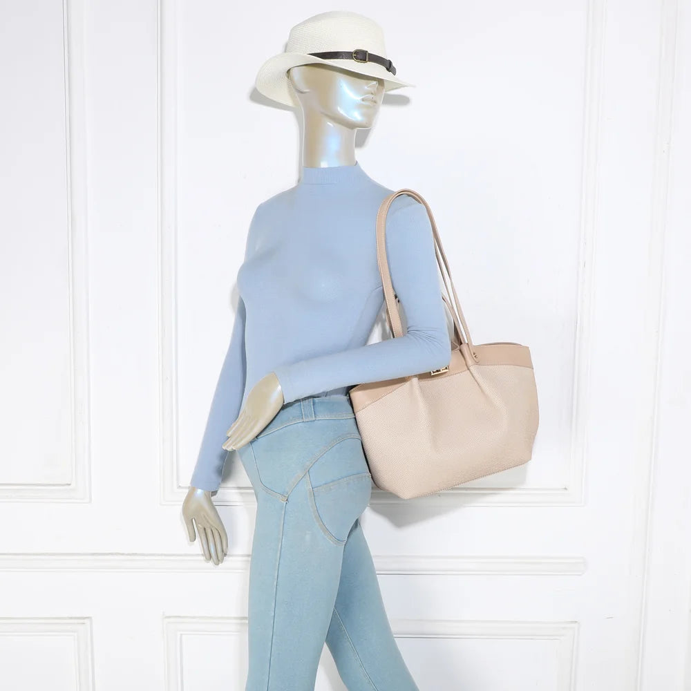 Sac Solara taupe porté par une femme, à l’épaule grâce à ses anses longues – réf. DQ-8729