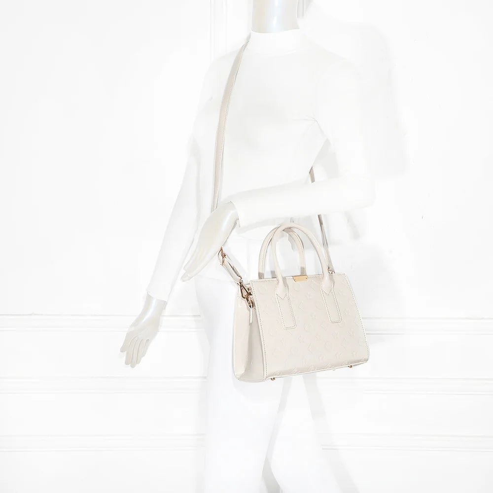 Sac Stella beige porté par une femme, tenu à la main pour une silhouette chic et structurée – réf. R-1627-2