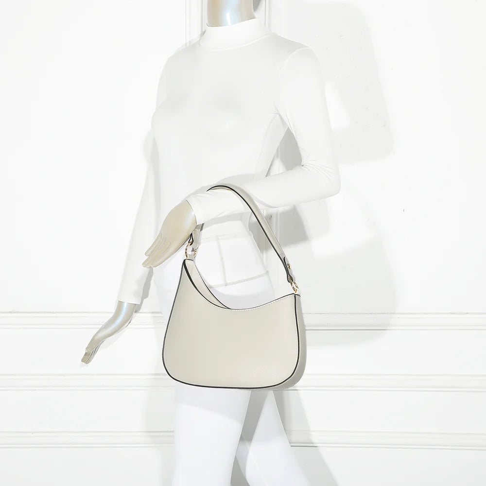 Sac Tereza beige porté par une femme, à l’épaule ou en bandoulière grâce à la sangle amovible – réf. R-1957