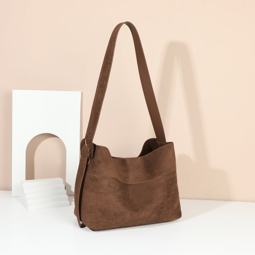 Sac hobo Vanys marron effet suédine mis en scène dans un décor chaleureux – visuel d’ambiance créé avec l’IA – Gallantry Paris