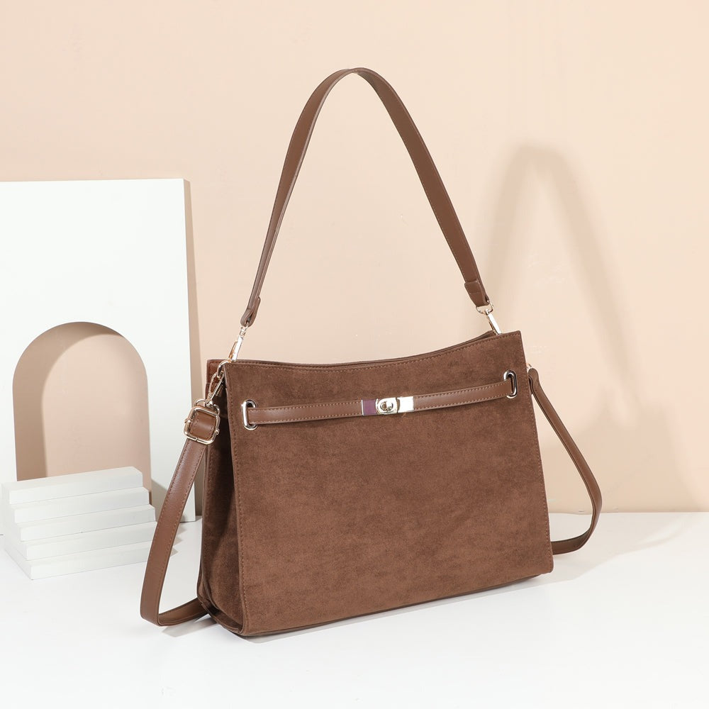 Sac à main Véla marron effet suédine à fermoir doré posé dans un décor chaleureux – visuel d’ambiance créé avec l’IA – Gallantry Paris