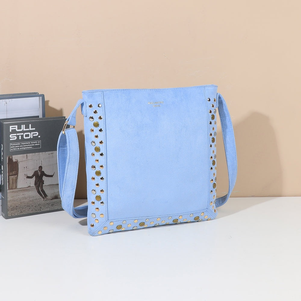 Sac bandoulière Velia bleu clair clouté mis en scène dans un décor – visuel d’ambiance créé avec l’IA – Gallantry Paris