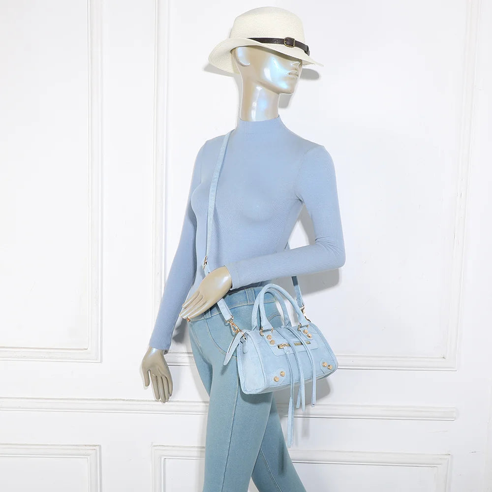 Velora bleu clair porté par une femme, sac à main compact effet suédine aux détails dorés – réf. KJ-62088