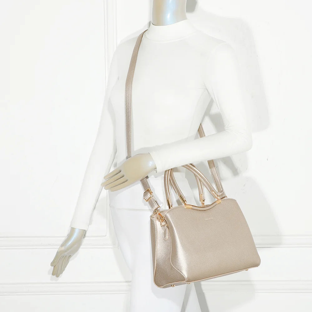 Sac Victoria Élégance or porté par une femme, tenu à la main par ses deux anses dorées – réf. R-1992