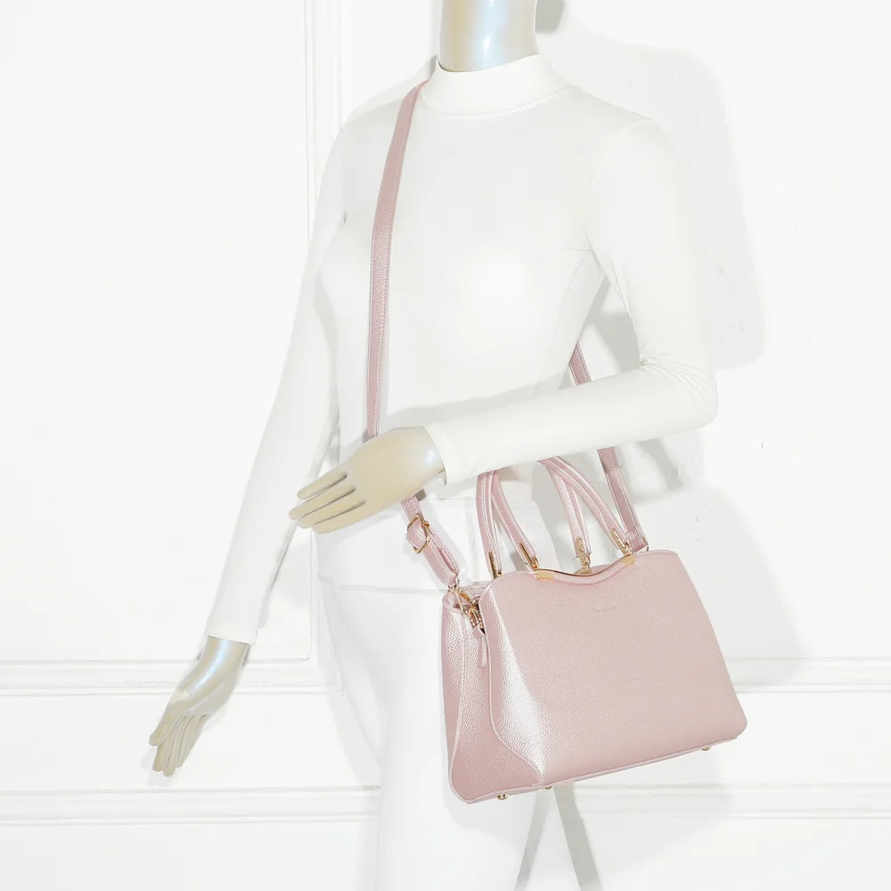 Sac Victoria Élégance rose porté par une femme, tenu à la main par ses deux anses dorées – réf. R-1992